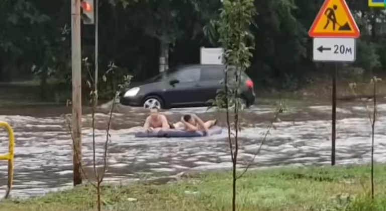 Мужики плывут на матрасе по улице в Тольятти