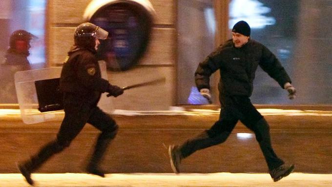 Протестующий убегает от полицейского